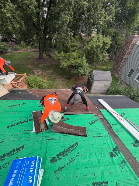 Rocket Roofing crew laying shingles over green synthetic underlayment on a Minnesota home