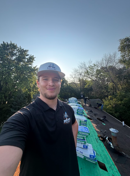 Shingle bundles staged along the ridge of a roof mid-replacement
