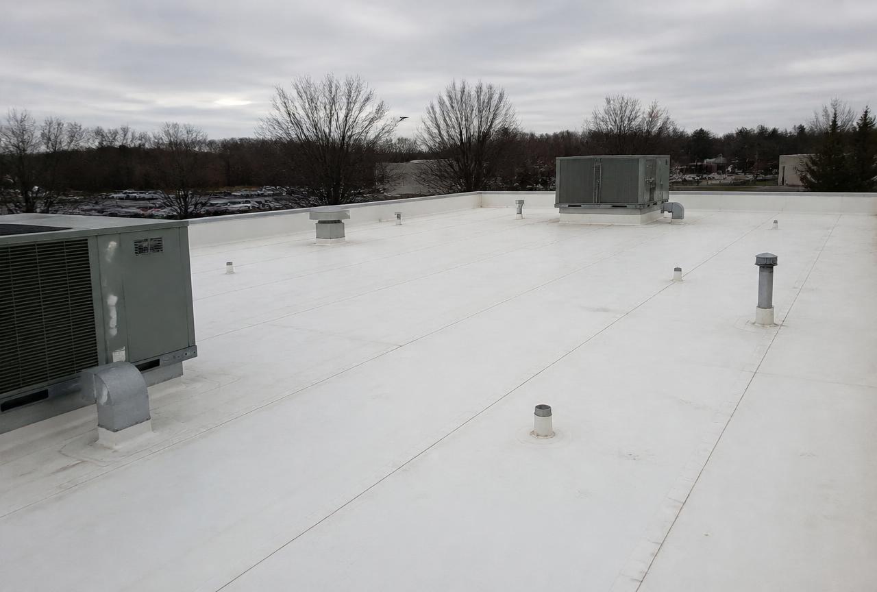 White TPO membrane commercial flat roof with rooftop HVAC units